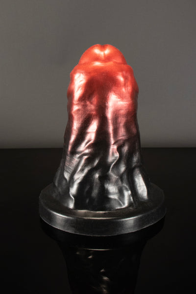 A front on product photo of Valac, the XXL monster dildo by Twisted Beast in a red-to-black ombre colour.