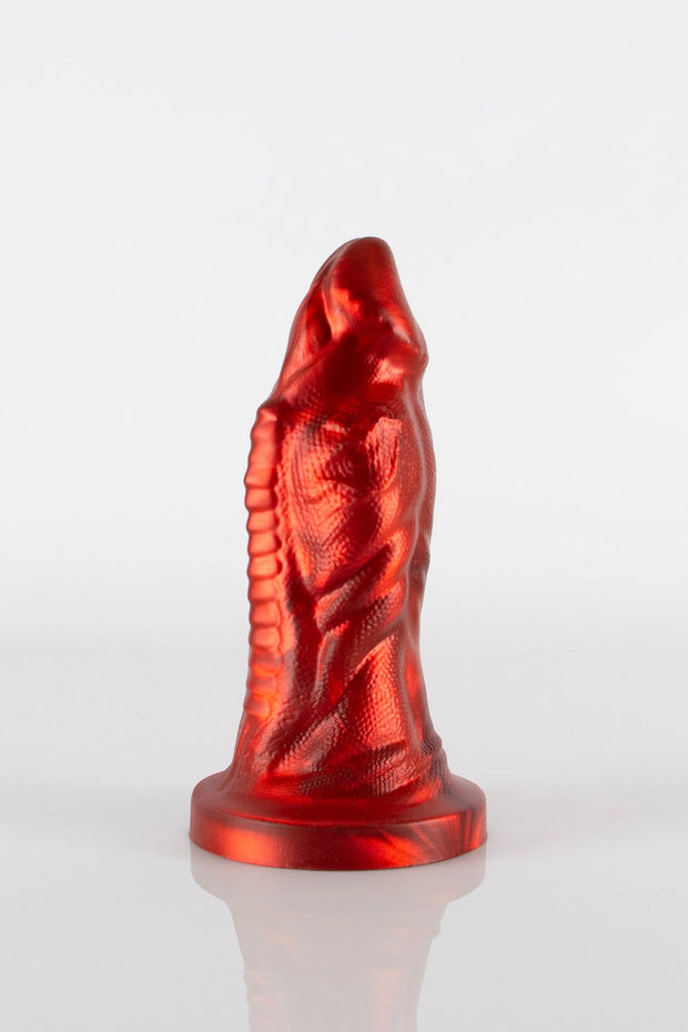 A product photo of a red reptile dildo showing off the detailed curves of the toy.