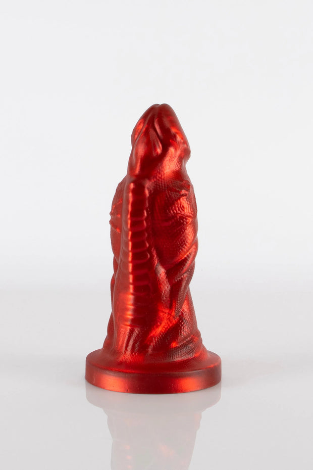 A product photo of a red reptile dildo showing off the toy&